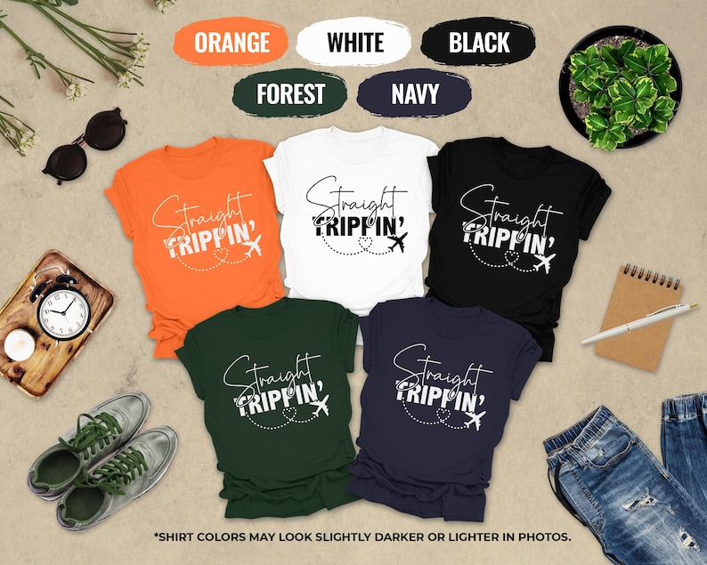 a collection of t-shirts with the text "Straight Tripin'" printed on them, along with various other items such as sunglasses, a clock, a plant, and a notebook.