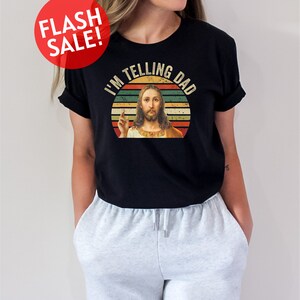 a woman wearing a black shirt with a picture of jesus on it