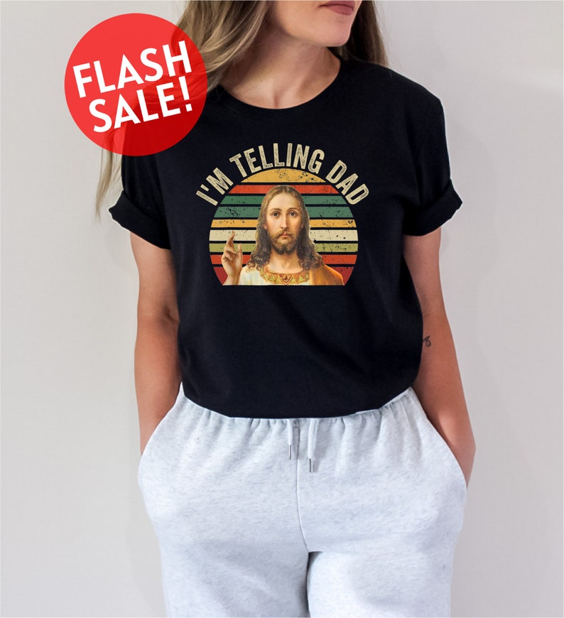 a woman wearing a black shirt with a picture of jesus on it