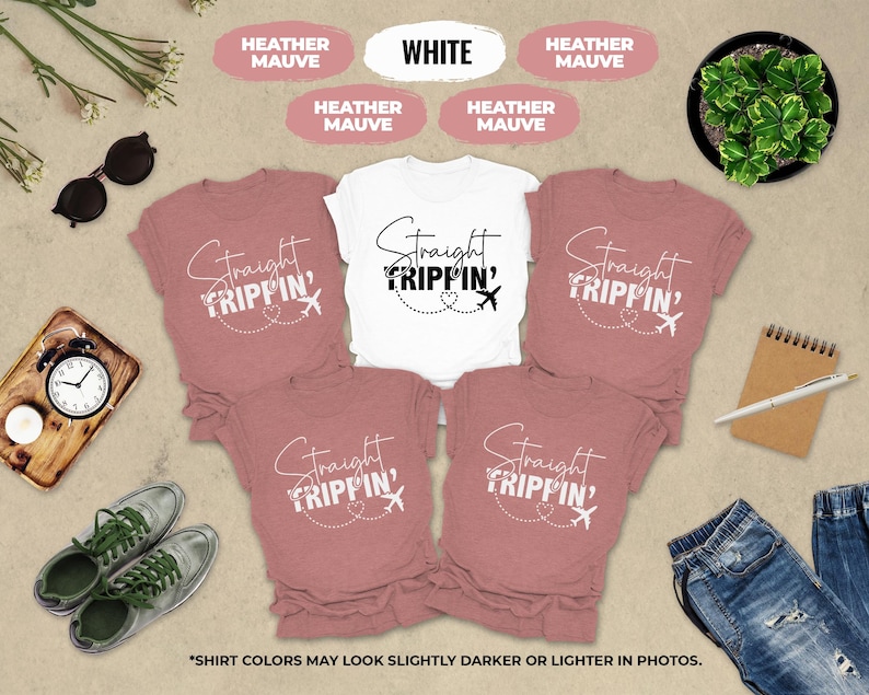 a collection of travel-themed items, including a white t-shirt with the text "Straight Tripin'", pink t-shirts, sunglasses, a clock, a plant, and a pair of jeans. The items are arranged on a beige background, creating a visually appealing and travel-inspired collage.
