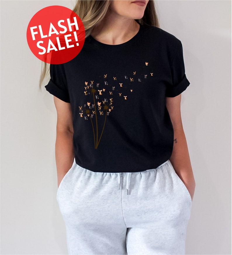 a woman wearing a black t - shirt with a dandelion design