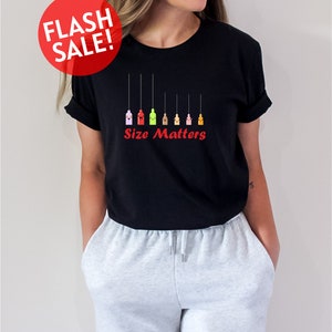 a woman wearing a black t - shirt that says size matters