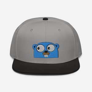 May include: A grey and black baseball cap with a blue and white embroidered cartoon gopher on the front.