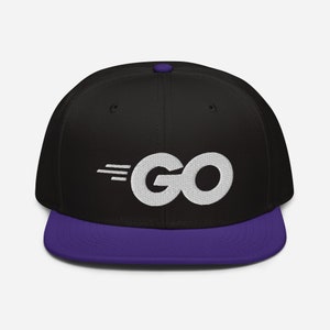 Peut inclure: Une casquette de baseball noire et violette avec un logo "GO" brodé en blanc avec un design de ligne de vitesse.