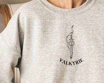 Może przedstawiać: Szara bluza z czarnym nadrukiem przedstawiającym miecz i napis "VALKYRIE" z przodu.