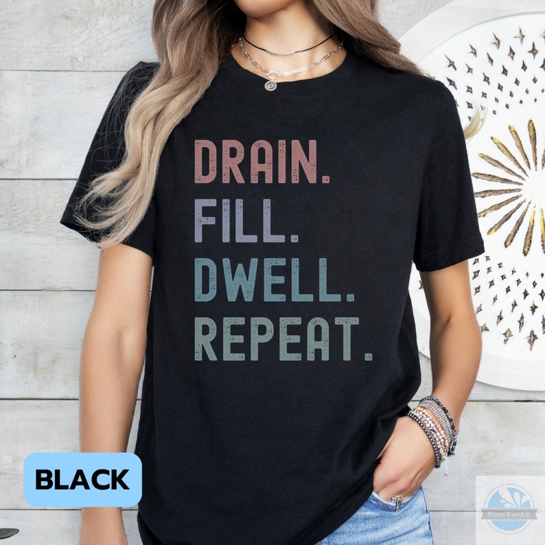 May include: Black t-shirt with the text "DRAIN. FILL. DWELL. REPEAT." in a vintage style font.