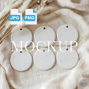 May include: A mockup featuring six white, round ceramic ornaments with gold string, arranged on a cream-colored fabric. The image includes "JPG" and "PNG" file type icons, and the word "MOCKUP" is displayed in the center.
