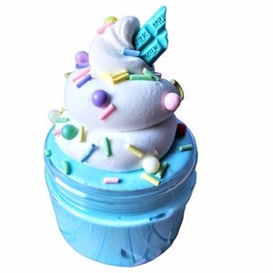 May include: A blue slime jar with a white whipped cream topping, colorful sprinkles, and a blue chocolate bar with "MILK" written on it.