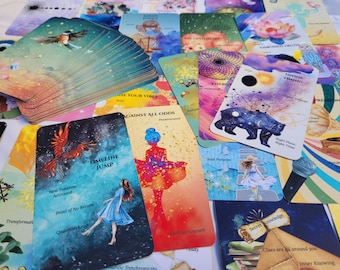 May include: A deck of oracle cards featuring colorful illustrations and text. Visible cards include 'Timeline Jump' with a person in a blue dress, 'Against All Odds' with a figure in a red dress, and 'Divine Timing' with a bear and celestial imagery.