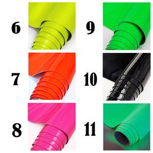 May include: A collection of six rolls of glossy adhesive vinyl in various colors, labeled with numbers 6 through 11. The colors include lime green, bright orange, hot pink, vibrant green, glossy black, and a teal green shade.
