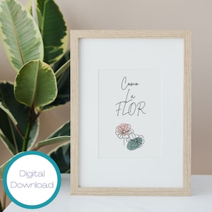 Op de afbeelding: Een downloadbare digitale print van een ingelijst afdruk met de Spaanse tekst "Como la Flor" en een eenvoudige lijntekening van drie bloemen in roze, groen en blauw.