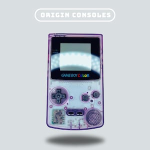 May include: A purple Game Boy Color handheld video game console with a white screen and the text "GAME BOY COLOR" on the front. The console has a purple and white color scheme and features a directional pad, buttons, and a screen.