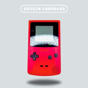 Puede incluir: Una consola de videojuegos portátil Game Boy Color roja con una pantalla en blanco y negro y botones. La consola tiene el texto "GAME BOY COLOR" impreso en la parte delantera.