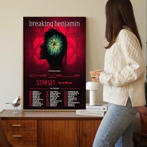 May include: A framed Breaking Benjamin concert poster with a red background and a silhouette of a person's head with a green and yellow design. The poster also lists tour dates and special guests.
