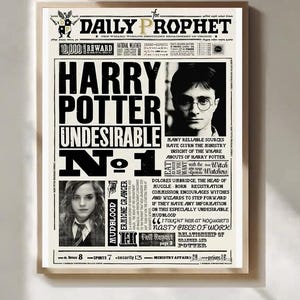 Może przedstawiać: Oprawiony wydruk gazety The Daily Prophet z nagłówkiem "Harry Potter Niepożądany Nr 1". Zawiera zdjęcia Harry'ego Pottera i Hermiony Granger. Wydruk ma estetykę vintage gazety.