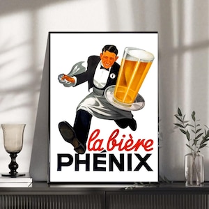 May include: Vintage advertisement print featuring a waiter in a tuxedo carrying a large glass of beer on a tray. The poster has the words "la bière PHENIX" in red and black. The image is framed and displayed on a black cabinet.
