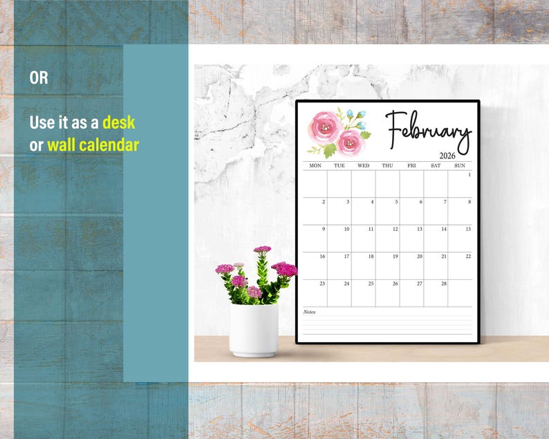 May include: A black framed calendar for February 2026, with floral accents. The calendar is displayed on a wooden surface, next to a small white pot with pink flowers. Text on the calendar includes the days of the week and dates.