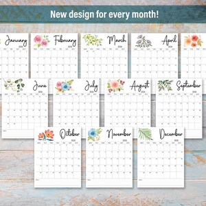 May include: A collection of twelve monthly calendars, each with a unique floral design at the top. The calendars are white with black text, and the text "New design for every month!" is at the top. The calendars are arranged on a light blue wooden surface.