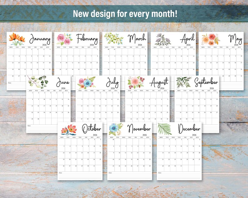 May include: A collection of twelve monthly calendars, each with a unique floral design at the top. The calendars are white with black text, and the text "New design for every month!" is at the top. The calendars are arranged on a light blue wooden surface.