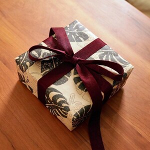 Gift-ready packaging available on request — leave a note at checkout. Each order ships in our signature monstera kraft wrap with a satin ribbon, as shown.
