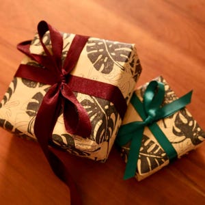 Gift-ready packaging available on request — leave a note at checkout. Each order ships in our signature monstera kraft wrap with a satin ribbon, as shown.