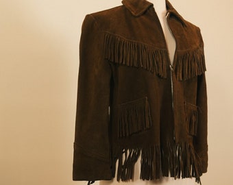 May include: A brown suede jacket with fringe detailing on the front, sleeves, and bottom hem. The jacket has a zipper closure and a pocket on the front.