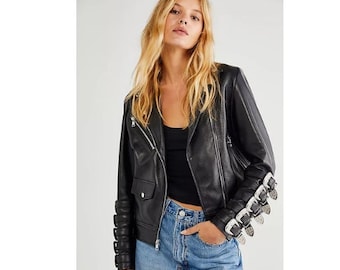May include: A black leather motorcycle jacket with silver buckle detailing on the sleeves. The jacket has a zipper closure and a stand-up collar.