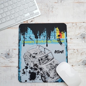 May include: A blue and white mouse mat with a black paint splatter design. The mouse mat features a black and white line drawing of a classic Mini car with the text "Owners Workshop Manual" and "MINI".