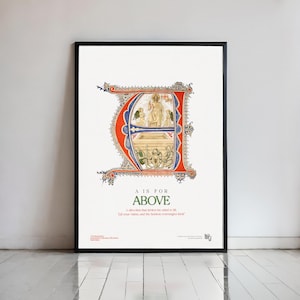May include: Framed art print with a detailed religious illustration inside a large, ornate letter "E". The artwork depicts figures and architecture, with the text "A IS FOR ABOVE". The frame is black.