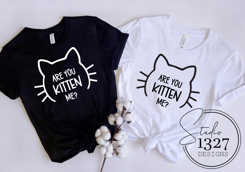 May include: Two t-shirts, one black and one white, with the text "Are you kitten me?" and a stylized cat face graphic.