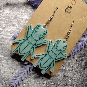 Light green stag beetle earrings with dark green outlines