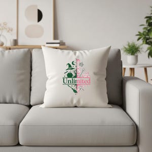 May include: White square pillow with a green and pink graphic design. The design is split in half, with a witch-themed side and a fairy-themed side. The word "Unlimited" is printed in the center.