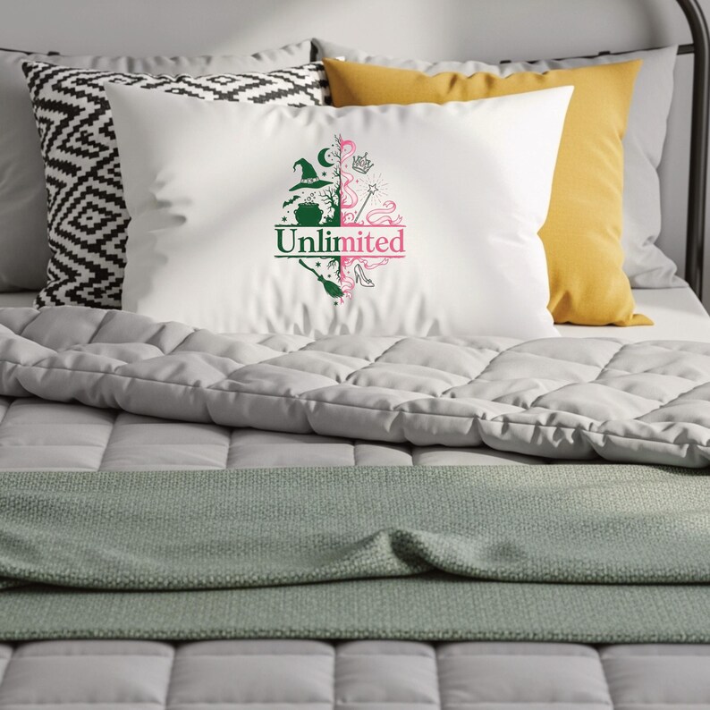 May include: White pillow with a green and pink graphic design featuring a witch's hat, broom, and high heel, with the word "Unlimited" in green and pink. The pillow is on a bed with other pillows and a gray comforter.