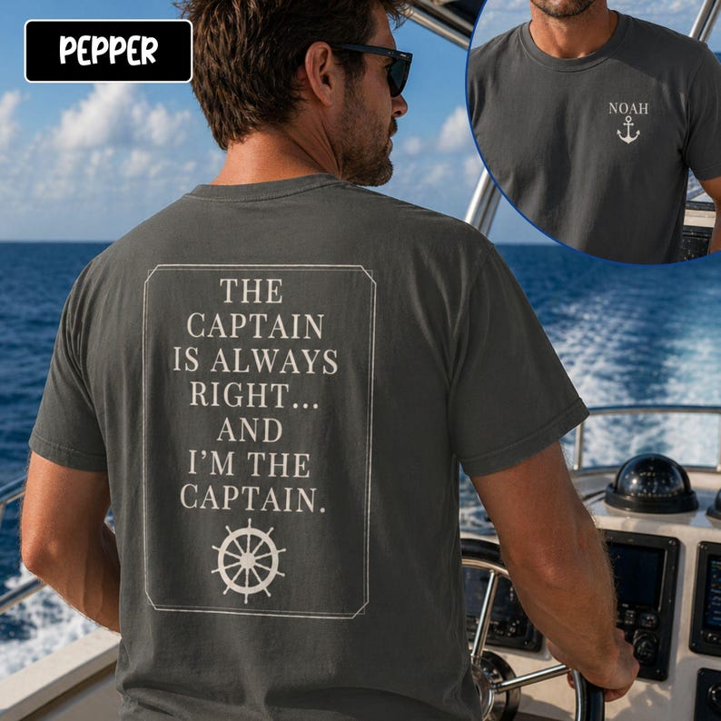 Pu&ograve; includere: T-shirt grigio scuro con la scritta "THE CAPTAIN IS ALWAYS RIGHT... AND I'M THE CAPTAIN" in un riquadro rettangolare bianco. La maglietta presenta anche una piccola grafica di un'ancora e il nome "NOAH" sul davanti. La persona indossa occhiali da sole ed &egrave; su una barca.