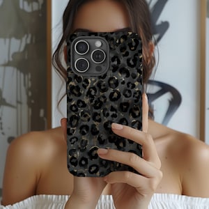 以下が含まれることがあります： iPhone 用の黒と金のレオパード柄の電話ケース