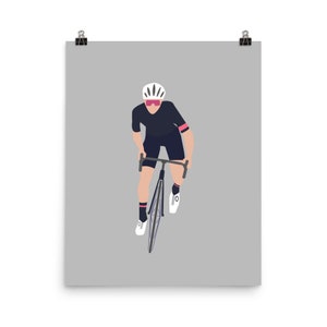 Può includere: Un ciclista con un casco bianco, una maglia nera e pantaloncini rosa guida una bicicletta nera con una sella bianca e un manubrio nero.
