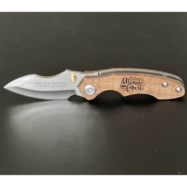 May include: A silver pocket knife with a wooden handle engraved with the words "Always and Forever" and the date "05.27.2012".
