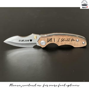 Peut inclure: Un couteau de poche à manche en bois brun et lame argentée. La lame est gravée de la date "01.08.2018" et d'un cœur. Le manche est gravé de "HII I Still Do".