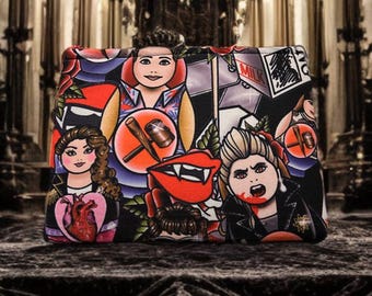 Può includere: Una pochette nera e rossa con cerniera, con una stampa grafica colorata che presenta personaggi dei cartoni animati, un cuore, una bocca di vampiro e la parola "MILK".