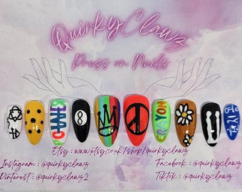 May include: A collection of press-on nails with diverse designs. The nails showcase a variety of colours and patterns, including a yellow nail with black spots, a black nail with an eight ball, and a red nail with a peace symbol. The text "QuirkyClawz Press on Nails" is visible.