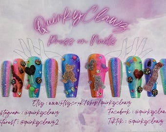 May include: A set of ten colorful press-on nails with various designs, including candy, a teddy bear, and a heart. The nails are decorated with glitter and rhinestones.  Etsy: www.etsy.co.uk/shop/quirkyclawz Facebook: @quirkyclawz Instagram: @quirkyclawz Pinterest: @quirkyclawz2 Tiktok: @quirkyclawz