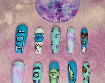 Puede incluir: Conjunto de diez uñas postizas azules y blancas con varios diseños, incluyendo la palabra coreana "BT21" y personajes de dibujos animados.