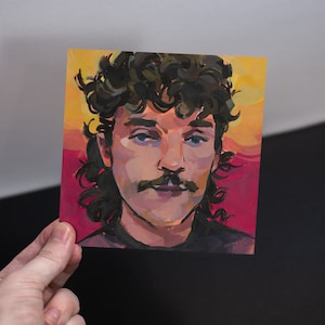 May include: A painting of a person with dark curly hair, a mustache, and a blue eye. The background is a gradient of yellow, orange, red, and pink.