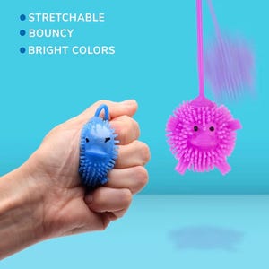 May include: A hand holds a blue, spiky toy shaped like a duck. A pink, spiky ball toy with a face is suspended by a string. Text on the left reads: Stretchable, Bouncy, Bright Colors. The background is a light blue.