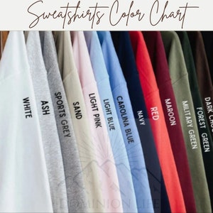 Puede incluir: Carta de colores que muestra 12 colores diferentes de sudaderas, incluyendo negro, chocolate oscuro, verde bosque, verde militar, granate, rojo, azul marino, azul Carolina, azul claro, rosa claro, arena, gris deportivo, gris ceniza y blanco.