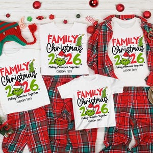 May include: Three white t-shirts with red and green text reading FAMILY Christmas 2026, Making Memories Together, and custom Text. Each shirt features a green character graphic wearing a Santa hat. The shirts are displayed with red plaid pants.