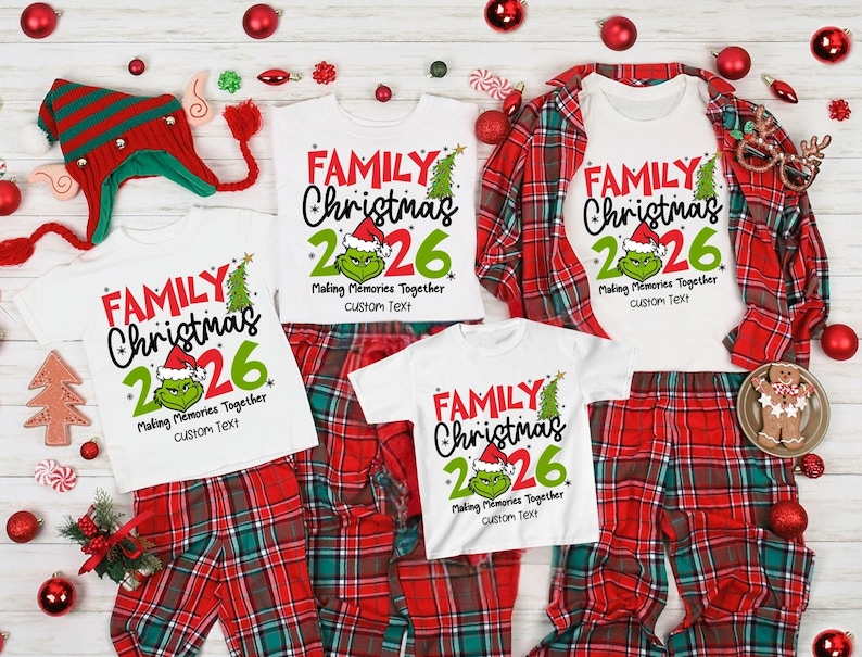May include: Three white t-shirts with red and green text reading FAMILY Christmas 2026, Making Memories Together, and custom Text. Each shirt features a green character graphic wearing a Santa hat. The shirts are displayed with red plaid pants.
