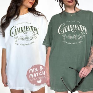 May include: A white t-shirt and a sage green t-shirt, each featuring the text "WITH LOVE FROM CHARLESTON" and "KATE'S BACHELORETTE - 2026" with line art of a cocktail, sun hat, flip-flops, and a flower. A circular pink logo reads "MIX & MATCH CUSTOM DESIGNS".