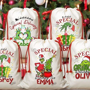 May include: Five white Christmas gift bags with red drawstrings. Each bag features a different Grinch-themed design with the words "Special Delivery" and a name. The bags are decorated with Christmas trees and gifts.