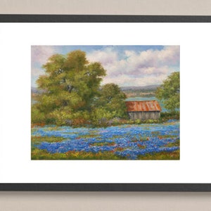 May include: A painting of a rustic wooden barn with a red metal roof, nestled in a field of bluebonnet wildflowers. The barn is surrounded by green trees and a blue sky with white clouds.